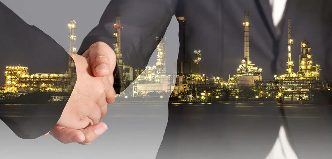Double Exposure of Handshake and Oil Refinery Industry Plant in the Night as Energy and Technology Concept